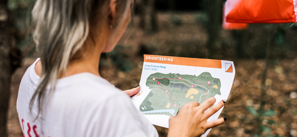 Teilnehmerin plant bei einer GPS-Orientierungstour mit Teamaufgaben die nächste Route.