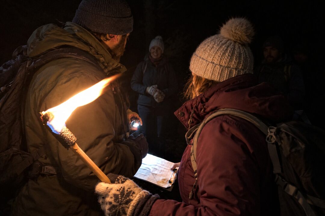 Teilnehmende bei Fackelwanderungen in der Nacht