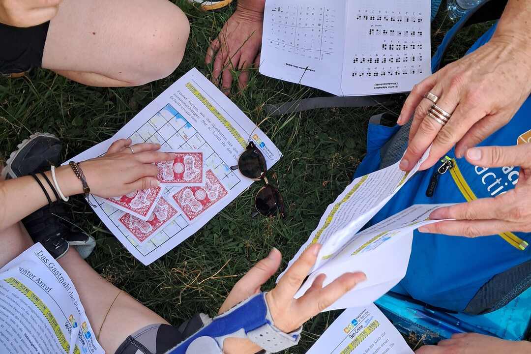 Team kombiniert Hinweise und Rätsel bei einer Outdoor-Ermittlung.